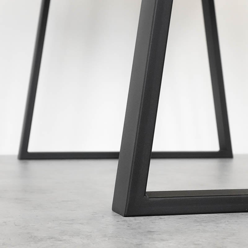 Svart metallbordben på grå golvyta.