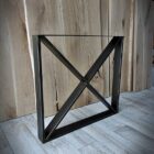 Svart metallställ mot trägolv och panel.