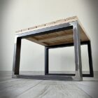 Bord med metallram och trätopp på trägolv.