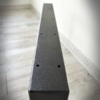 Svart metallbalk på ljus golv.