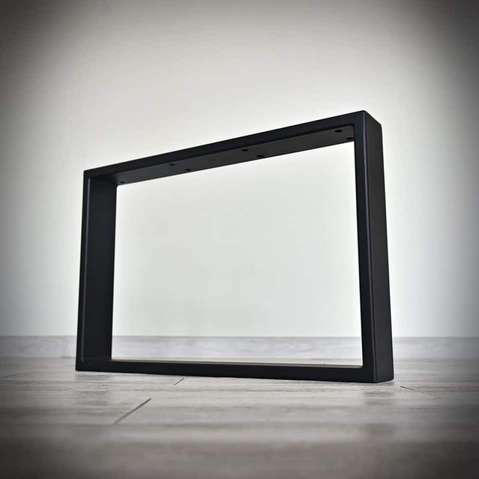 Svart rektangulärt bordsben på träyta.