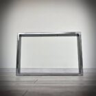 Metallram på trägolv mot vit vägg.