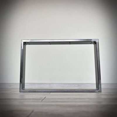 Metallram på trägolv mot vit vägg.