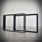 Svarta metallramar på ett trägolv.